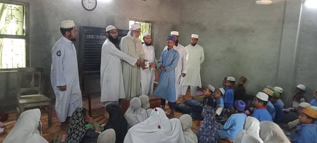 A teacher presenting a prize to a student at the term results ceremony