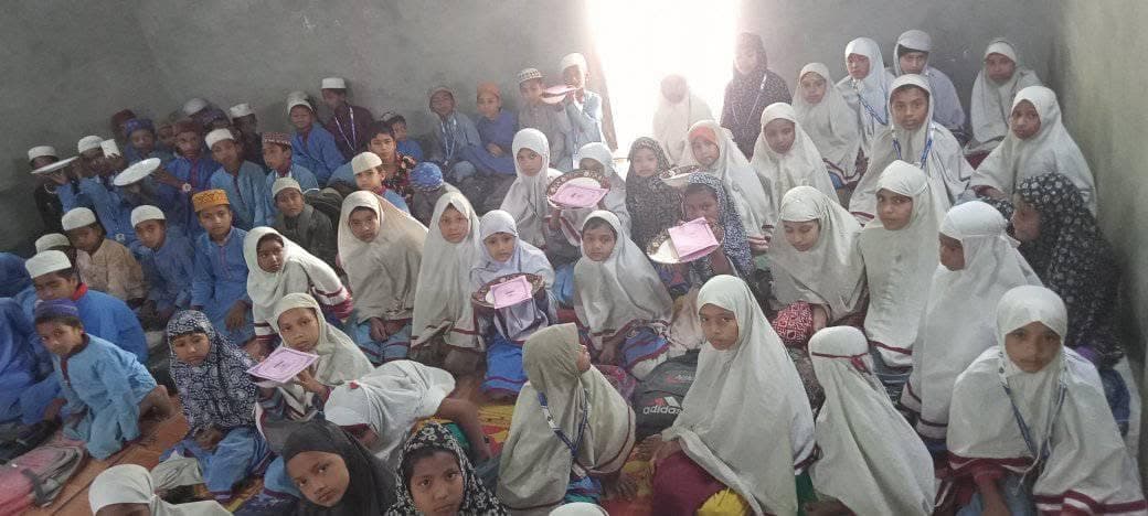 Students seated on the classroom floor holding their result slips