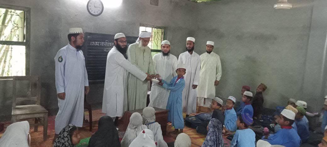 A student stepping forward to collect an award from the teachers