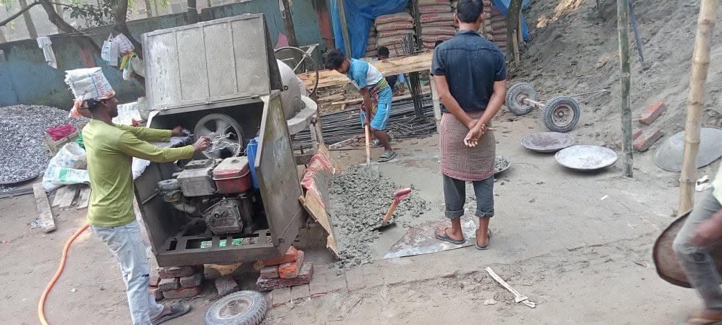 Workers mixing concrete on the new building site
