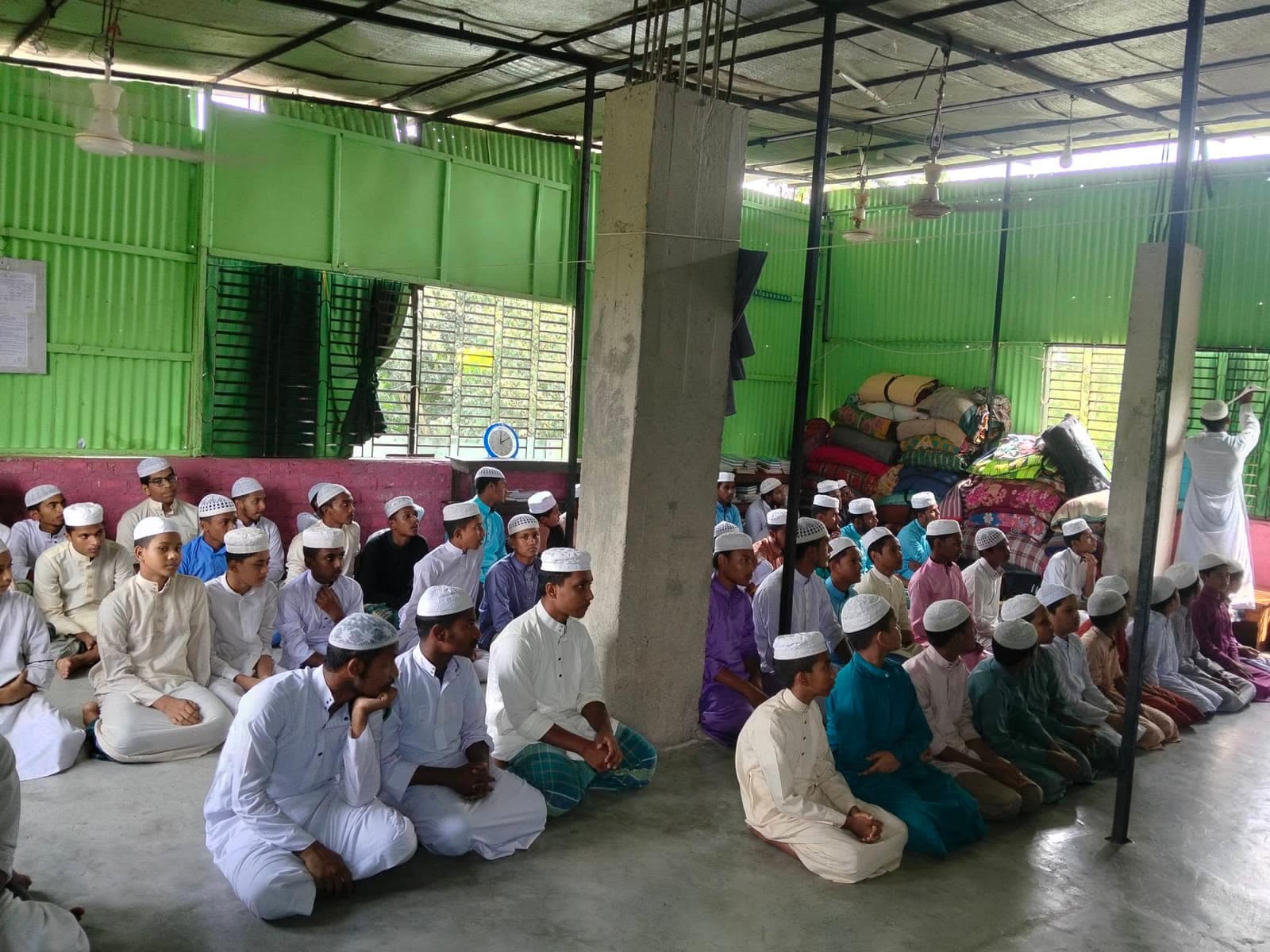 Students seated together for a lesson in the madrasa hall