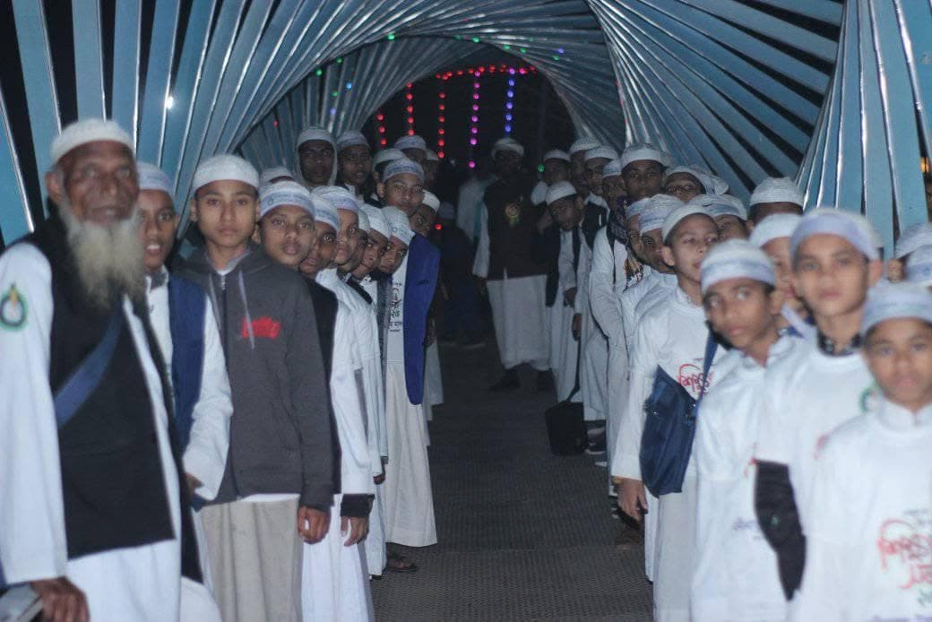 Students walking through a lit walkway in the evening on the study tour